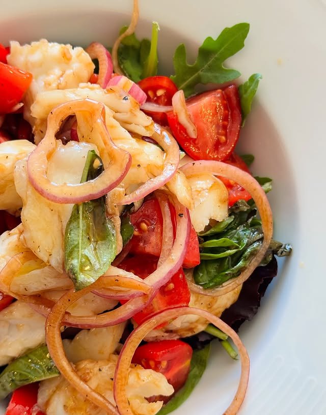 Insalata di mare con pomodorini, cipolla rossa e erbe fresche